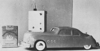 model car and its transmitter shown beside pack of cigarettes to indicate size - Airplanes and Rockets