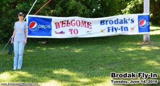 Supermodel Melanie next to the Brodak's 20th Annual Fly-In sign - Airplanes and Rockets