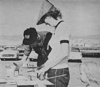 Bryant Thompson finger-paints on his A.M.A. license number assisted by his wife - Airplanes and Rockets