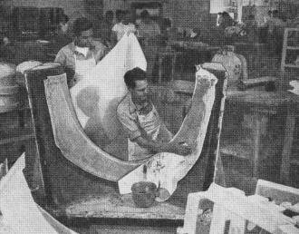 Workman in Northrop's plastic shop impregnates cloth in mold before laying on the pre-cut glass fiber - Airplanes and Rockets